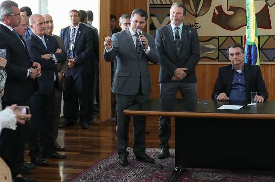 Autor do projeto que deu origem Ã  lei, o senador Marcos RogÃ©rio fala na cerimÃ´nia de sanÃ§Ã£o, ao lado do deputado Afonso Hamm e de Jair Bolsonaro