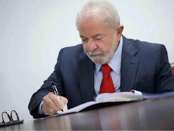 Lula assinando documento