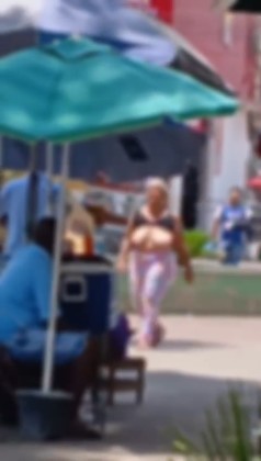 Mulher sem blusa no centro