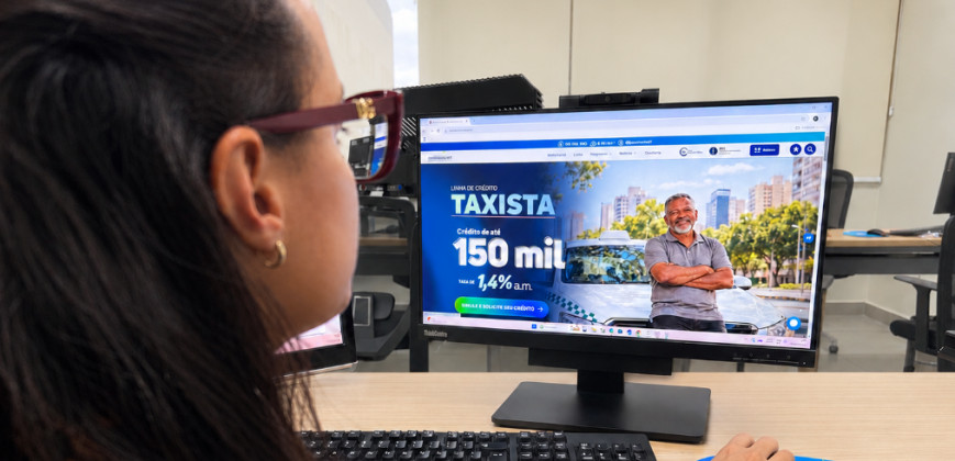 Mulher no escritório acessa crédito para taxistas.png