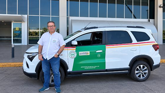 Funcionário diante de SUV no aeroporto.png